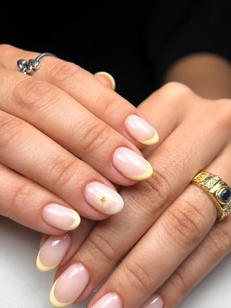 Manos con uñas naturales reforzadas y anillos dorados
