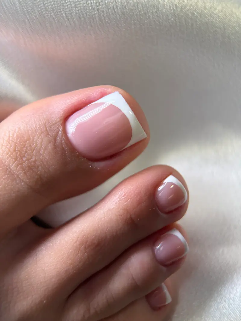 Detalle de una uña del pie con esmalte en gel y francesa